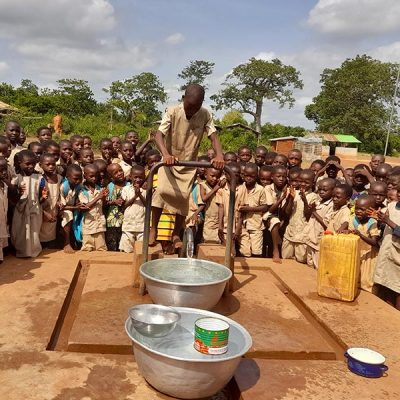 Bambini che raccolgono l'acqua al pozzo del villaggio di Domè in Benin
