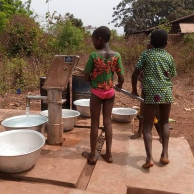Bambini che raccolgono l'acqua al pozzo del villaggio di Domè in Benin