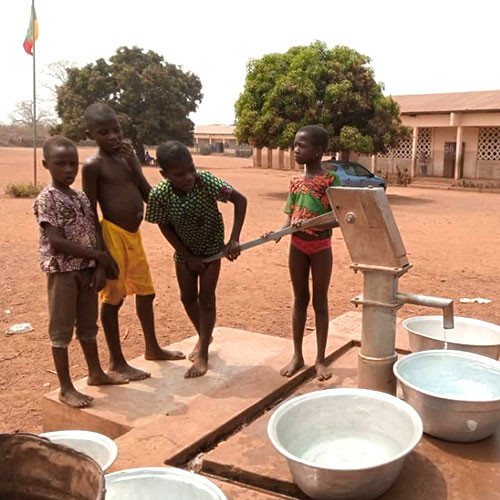 Bambini che raccolgono l'acqua al pozzo del villaggio di Domè in Benin