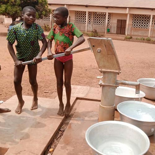 Bambini che raccolgono acqua pulita dal pozzo