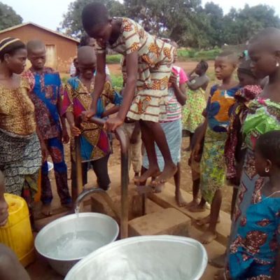 Bambini che raccolgono l'acqua al pozzo del villaggio di Domè in Benin