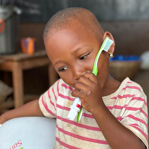 Bambina con spazzolino e dentifricio donati da CARA Africa al villaggio di Domè in Benin